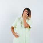 Miscarriage - A hopeful pregnant woman holding her baby bump with an ultrasound image in the background.